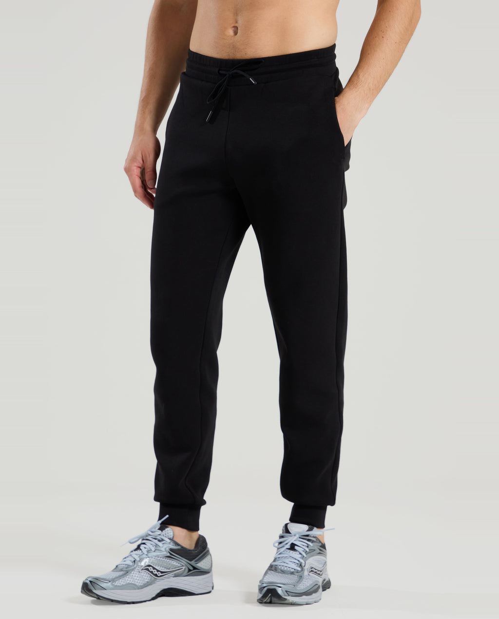 Person wearing red run black jogger pants on a light gray background