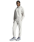 A woman standing, wearing a silver hoodie and matching silver pants with a relaxed fit, designed for running or leisure activities.