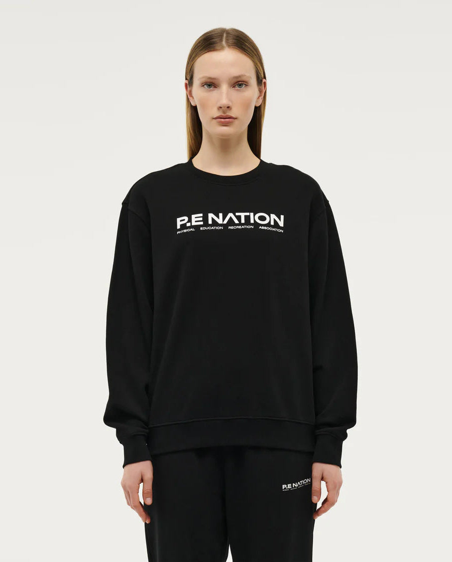 Model wearing P.E Nation Black round neck Sweater with a white background