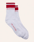 White socks with red accents and 'PE Nation' branding on a light pink background