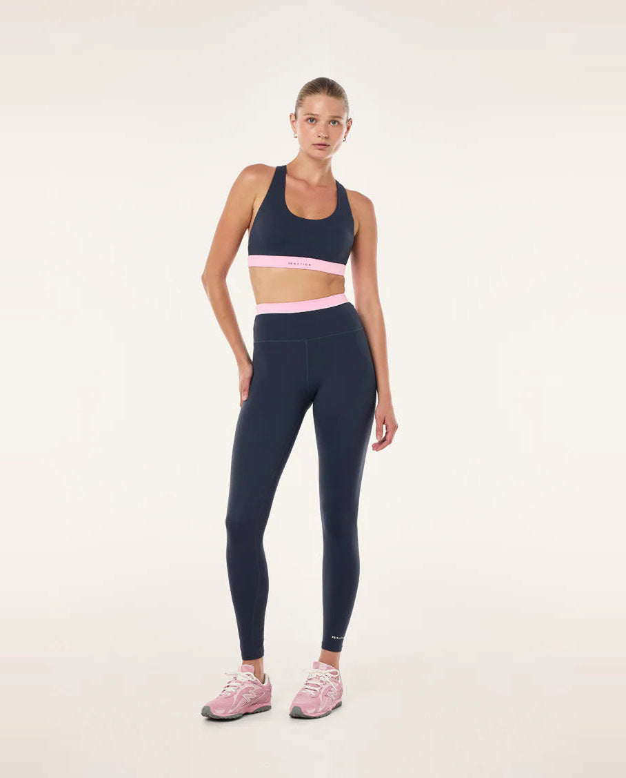 dark blue leggings with a pink waistband on a female model