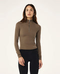 Woman wearing a brown long-sleeve top with a zipper on a white background