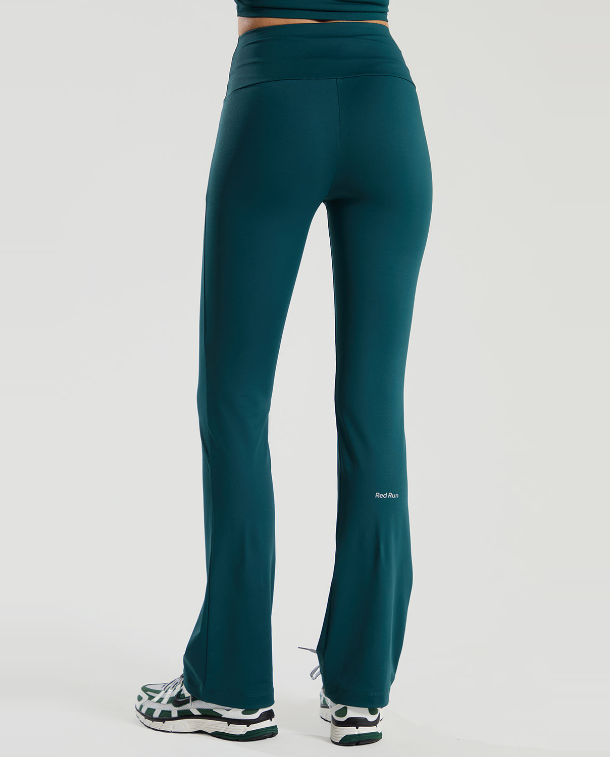 Teal pants  by red run worn by a person on a white background