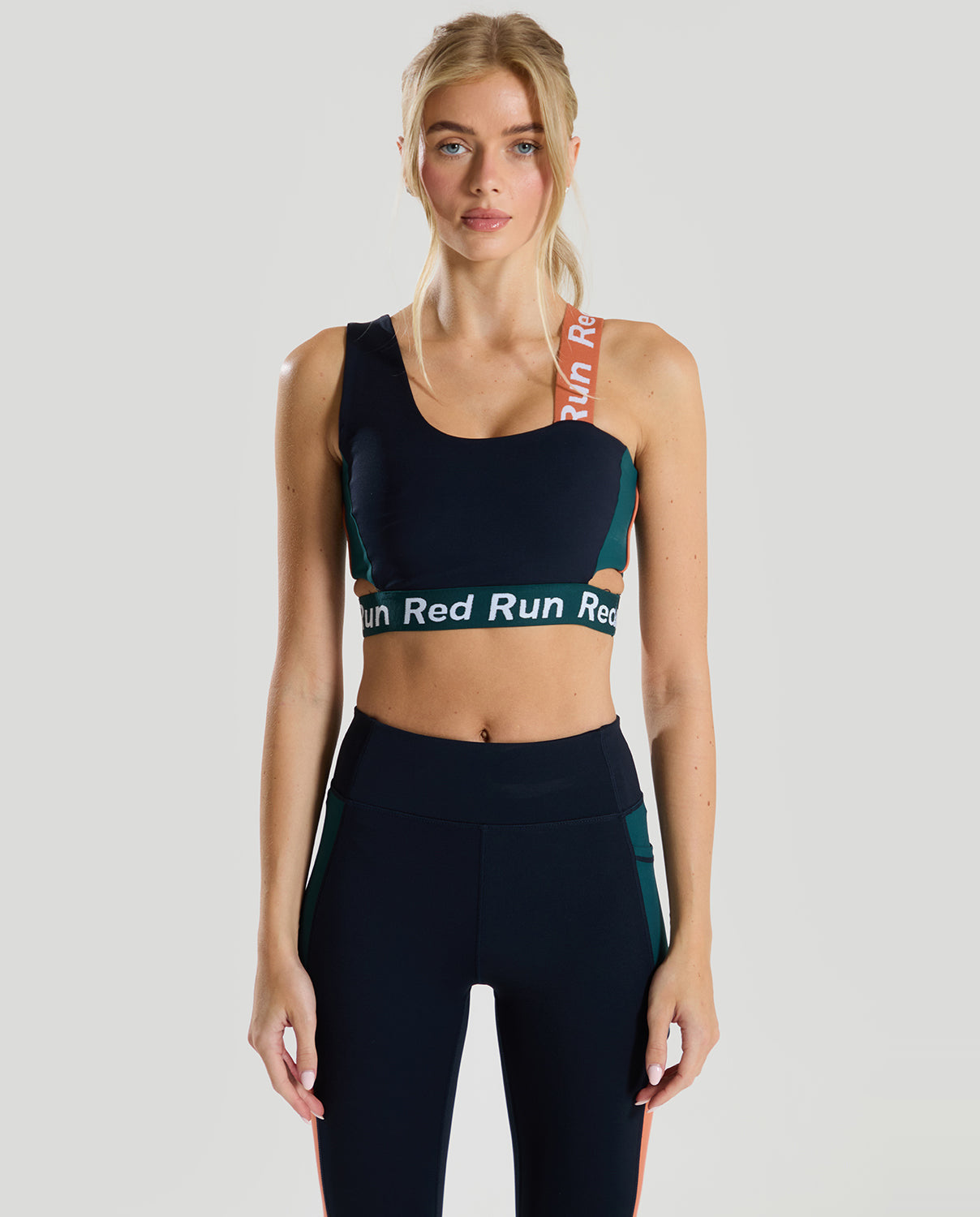 female in a red run navy blue sports bra