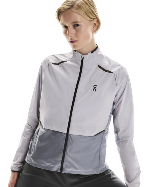 Woman wearing a light lilac jacket with black accents on a white background