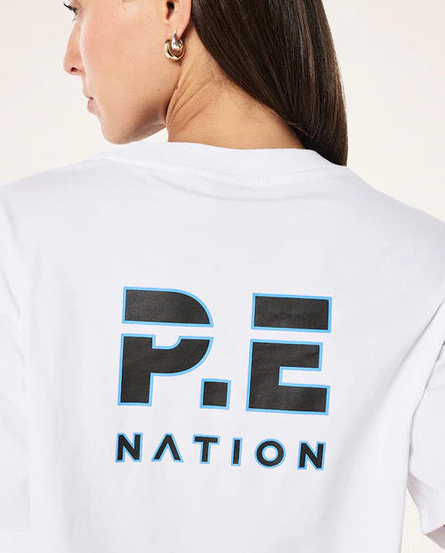 Person wearing a white t-shirt with 'P.E. Nation' logo on the back.