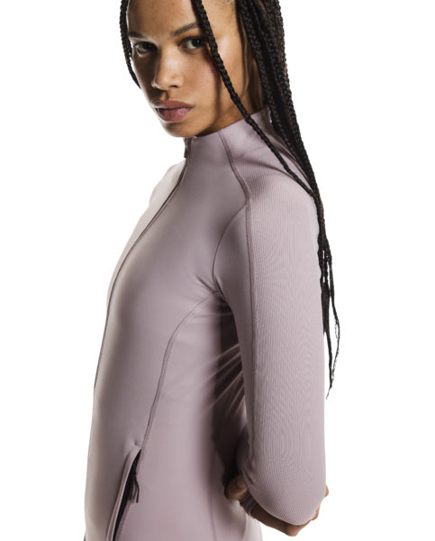 Woman wearing a light purple long-sleeve top on a white background