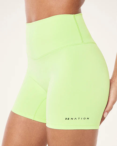Neon green shorts with 'P.E Nation' branding on a white background