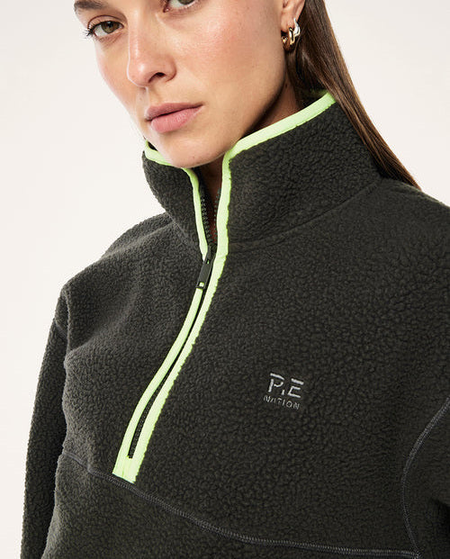 female model wearing  a grey teddy fleece with lime green highlights on a white background