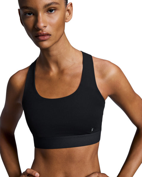 Person wearing a black sports bra against a white background