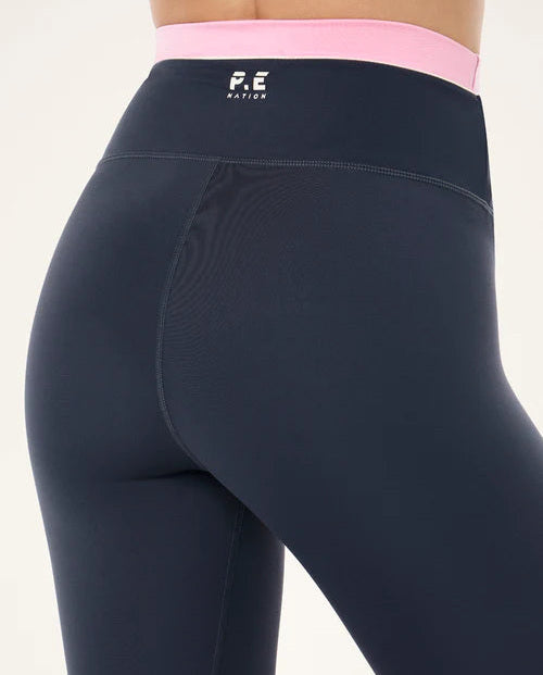 blue leggings with a pink waistabnd with a P.E nation visible logo on a model