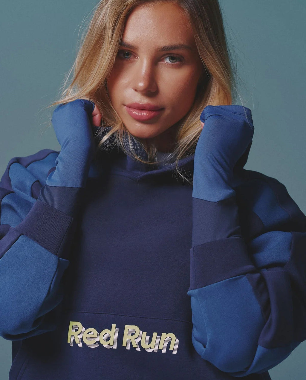 Person wearing a blue hoodie with 'Red Run' text against a teal background