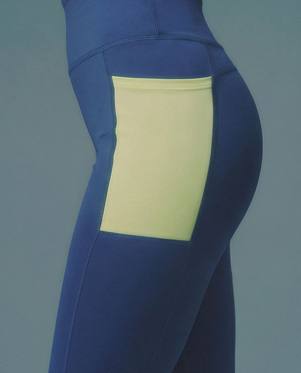Blue leggings with a yellow patch on a gray background