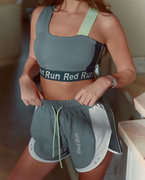 Person wearing a sports bra and shorts with 'Red Run' branding.