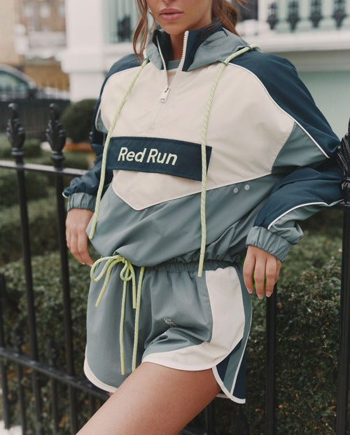Person wearing a 'Red Run' tracksuit in an urban setting