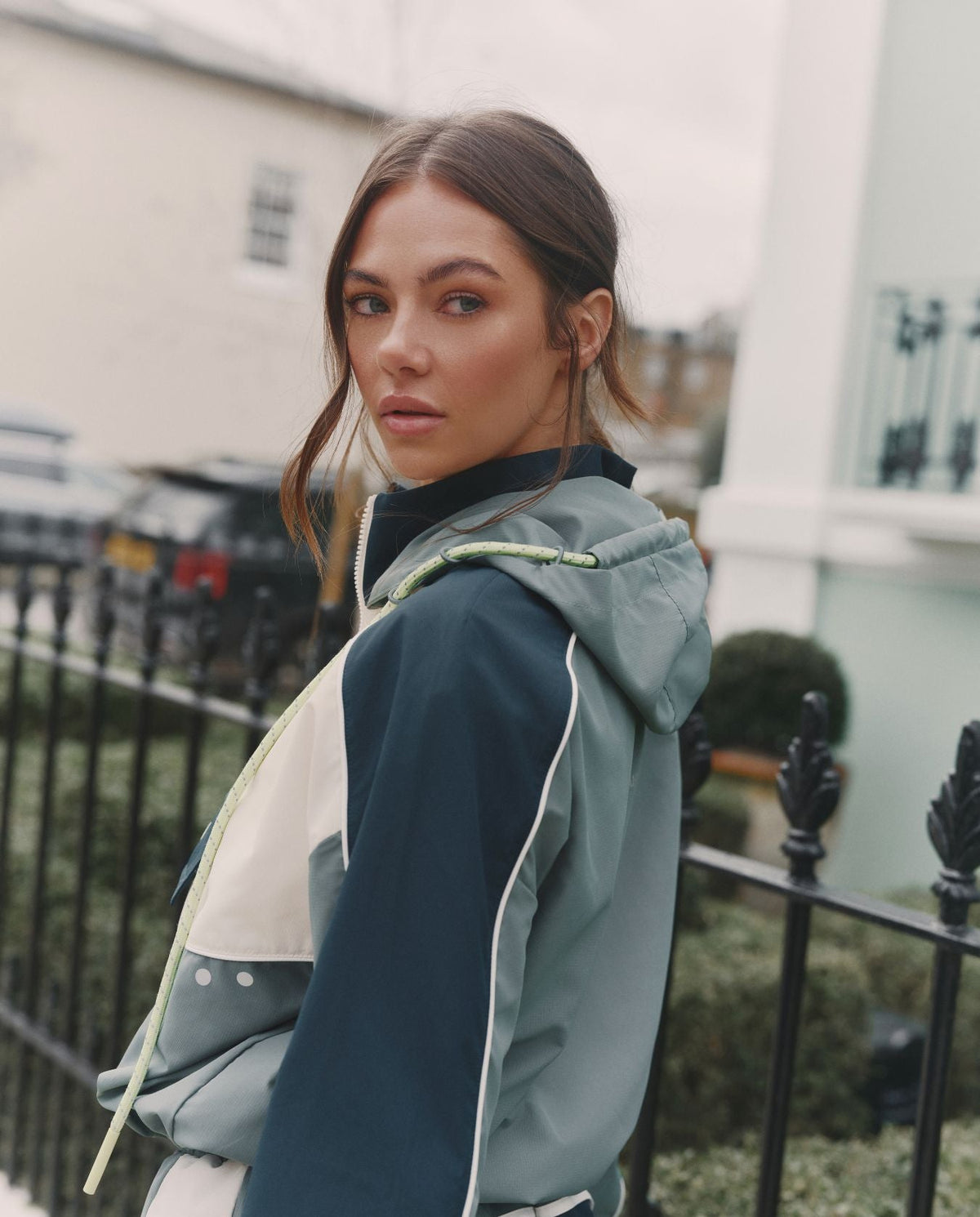 Woman wearing a blue and white jacket outdoors with a blurred background