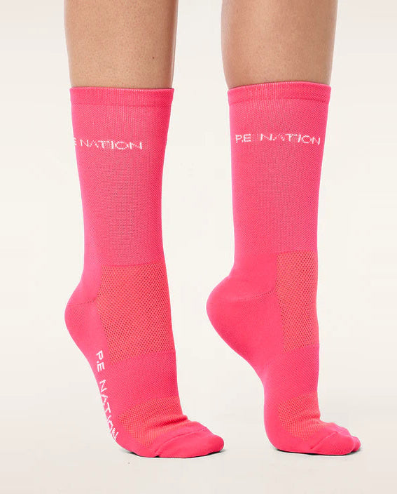 Pink socks with 'PE Nation' branding on a white background