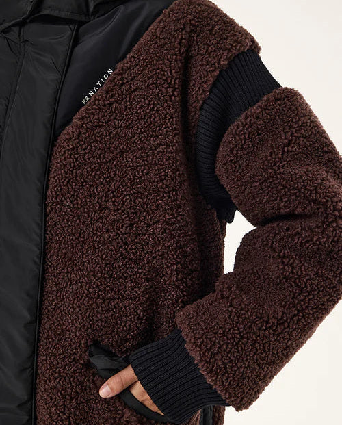 Close-up of a brown sherpa-lined jacket with black sleeves on a white background