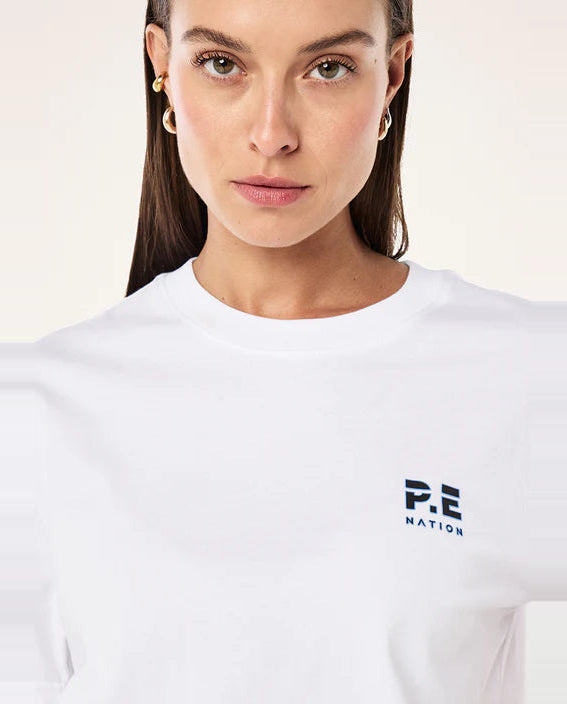 Person wearing a white t-shirt with a logo on a light background