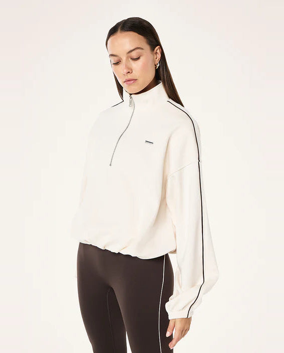 Woman wearing a white athletic jacket with black accents on a white background