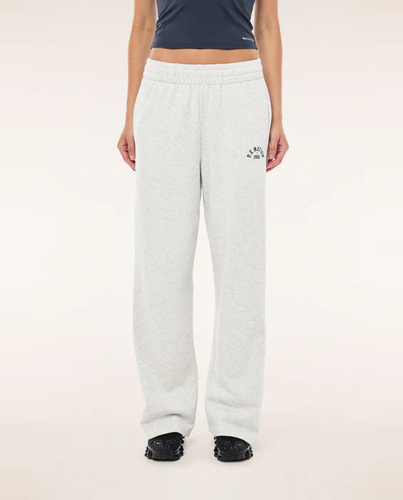 Person wearing white sweatpants with a logo on a plain background