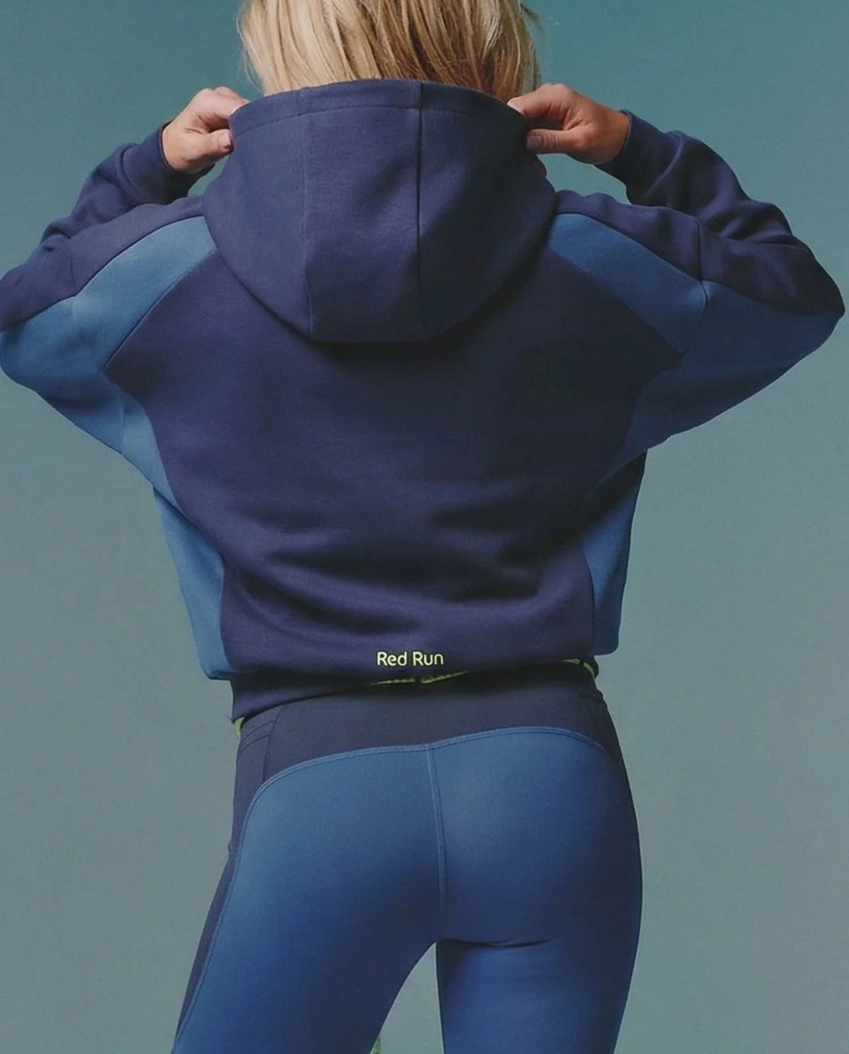 Person wearing a blue and purple hoodie with 'Red Run' branding on a solid background