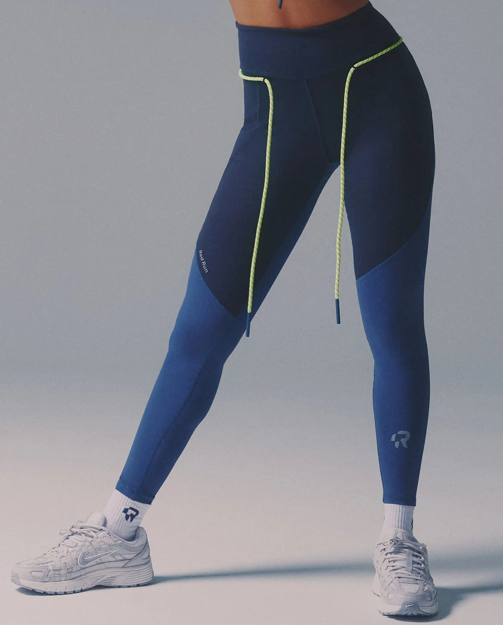 Person wearing blue and black leggings with a gray background