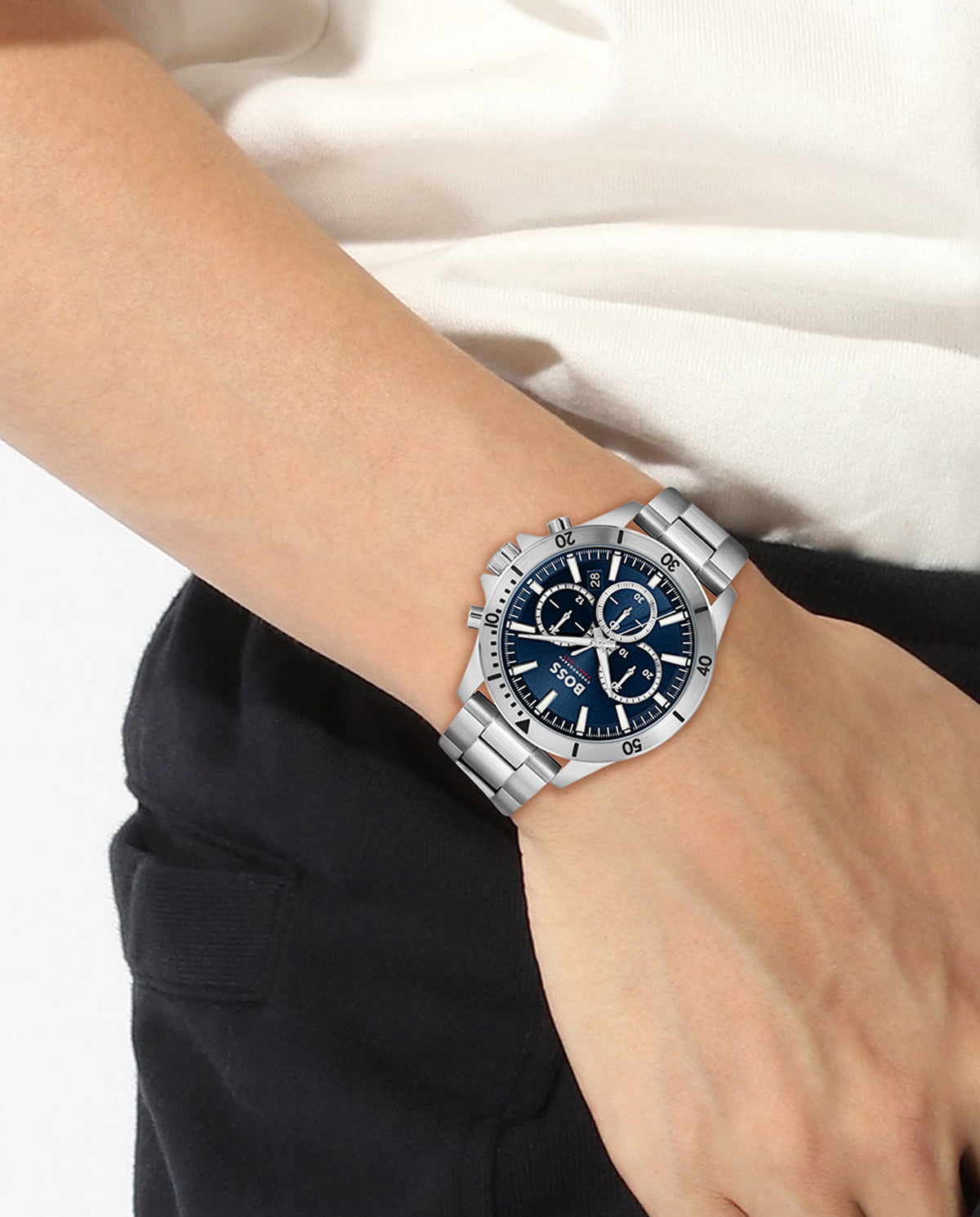 Close-up of BOSS Troper chronograph watch on wrist, showcasing stainless steel bracelet and blue dial detail.