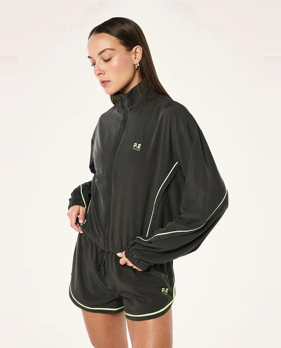Woman wearing a grey  tracksuit with a logo on a white background