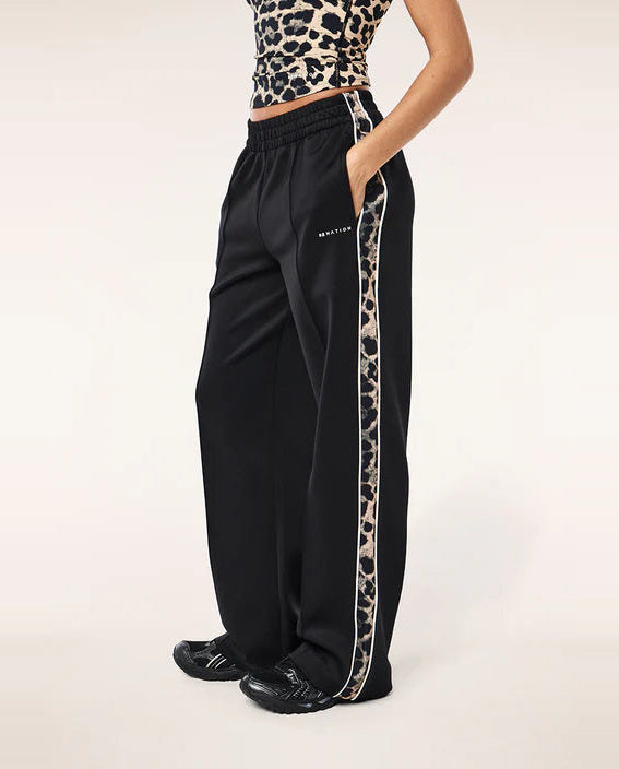 Black pants with leopard print side stripe worn by a person on a white background