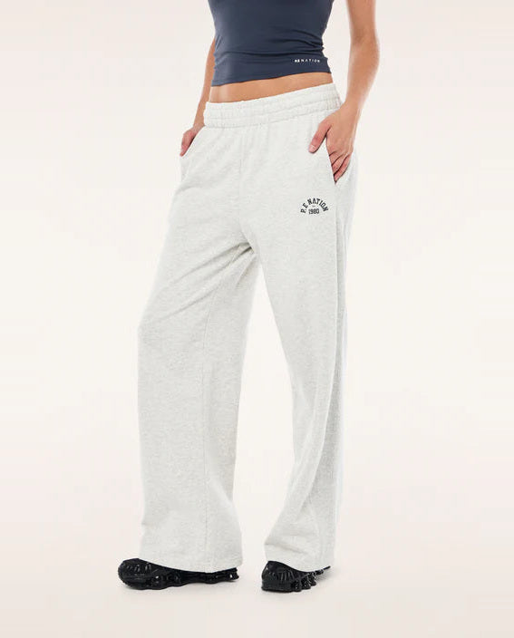 Person wearing light grey P.E nation sweatpants with a logo on a light pink background