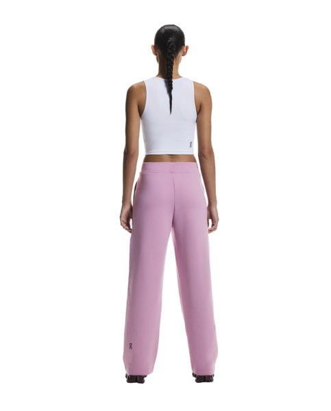 Person wearing a white crop top and pink pants on a white background