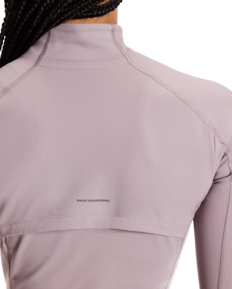 Close-up of a light purple athletic top with 'Swiss Engineering' text on a white background