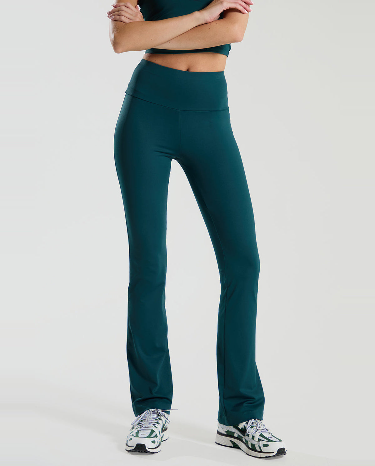 Person wearing teal green red run athletic pants on a white background