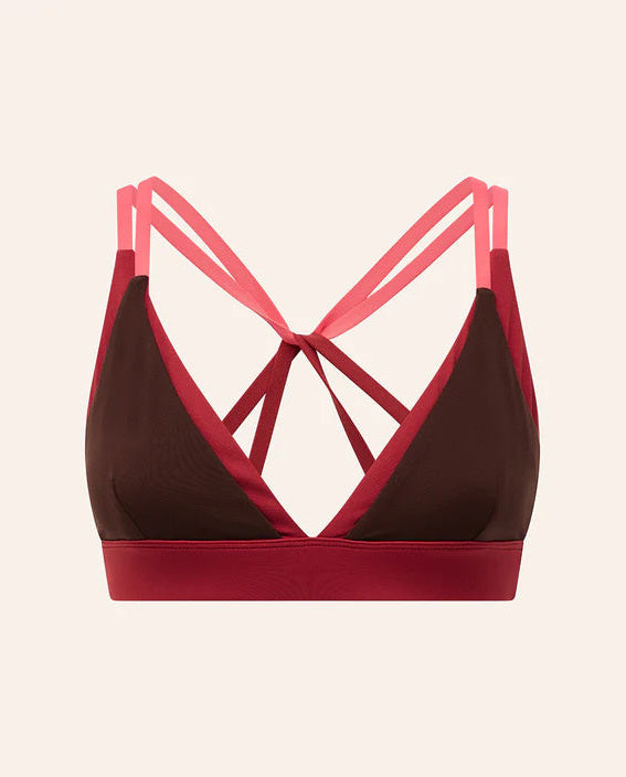 Brown and red sports bra with pink straps on a beige background