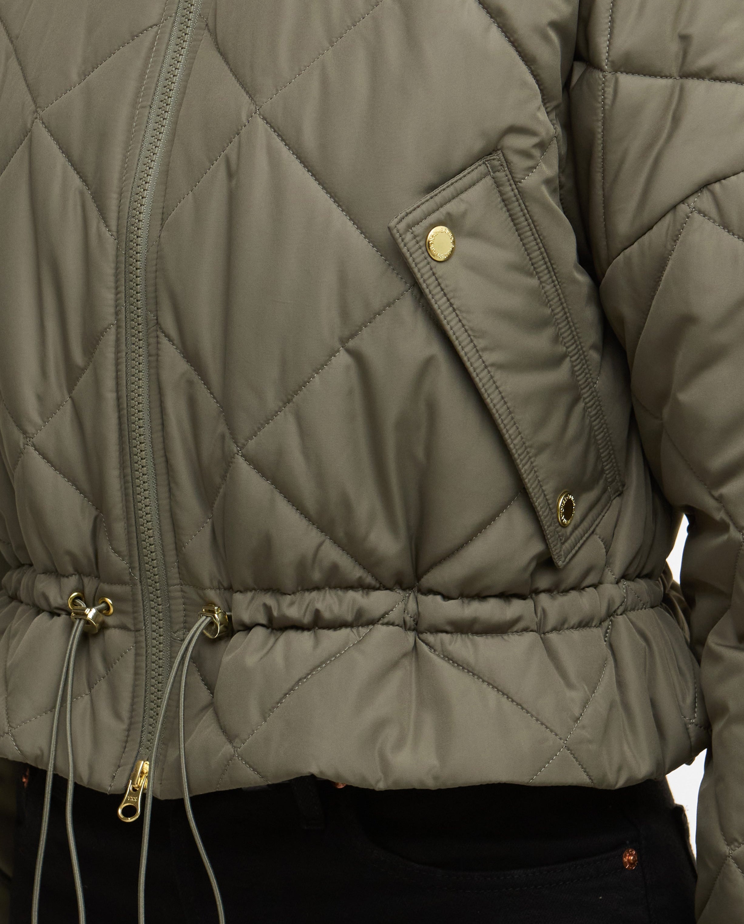 Quilted jacket with a focus on the quilted pattern and gold zippers.