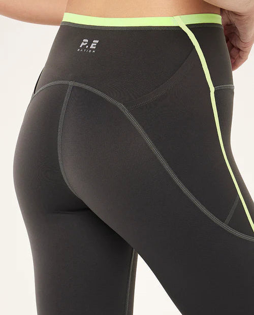 Grey leggings with neon green accents on a white background