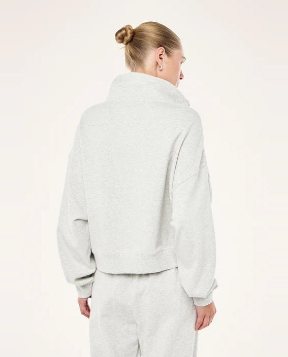Person wearing a light gray fleece jacket and pants on a white background