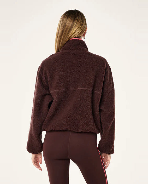 Person wearing a brown fleece jacket and pants on a white background