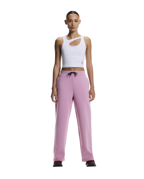 Woman wearing a white tank top and pink pants on a white background
