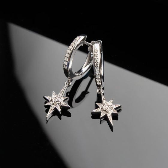 Pair of silver hoop earrings with star pendants.