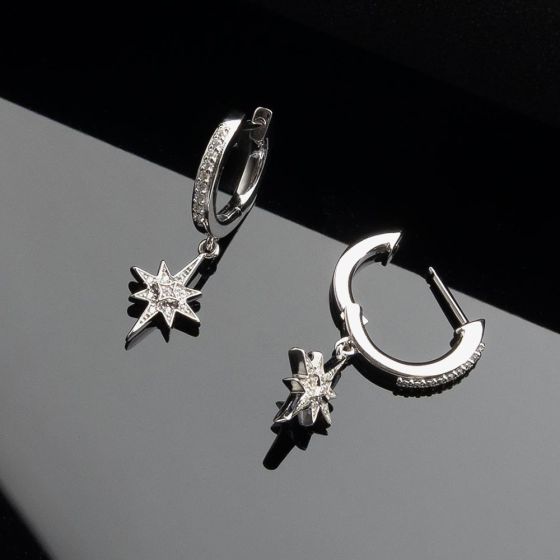 Two silver hoop earrings with star-shaped pendants.