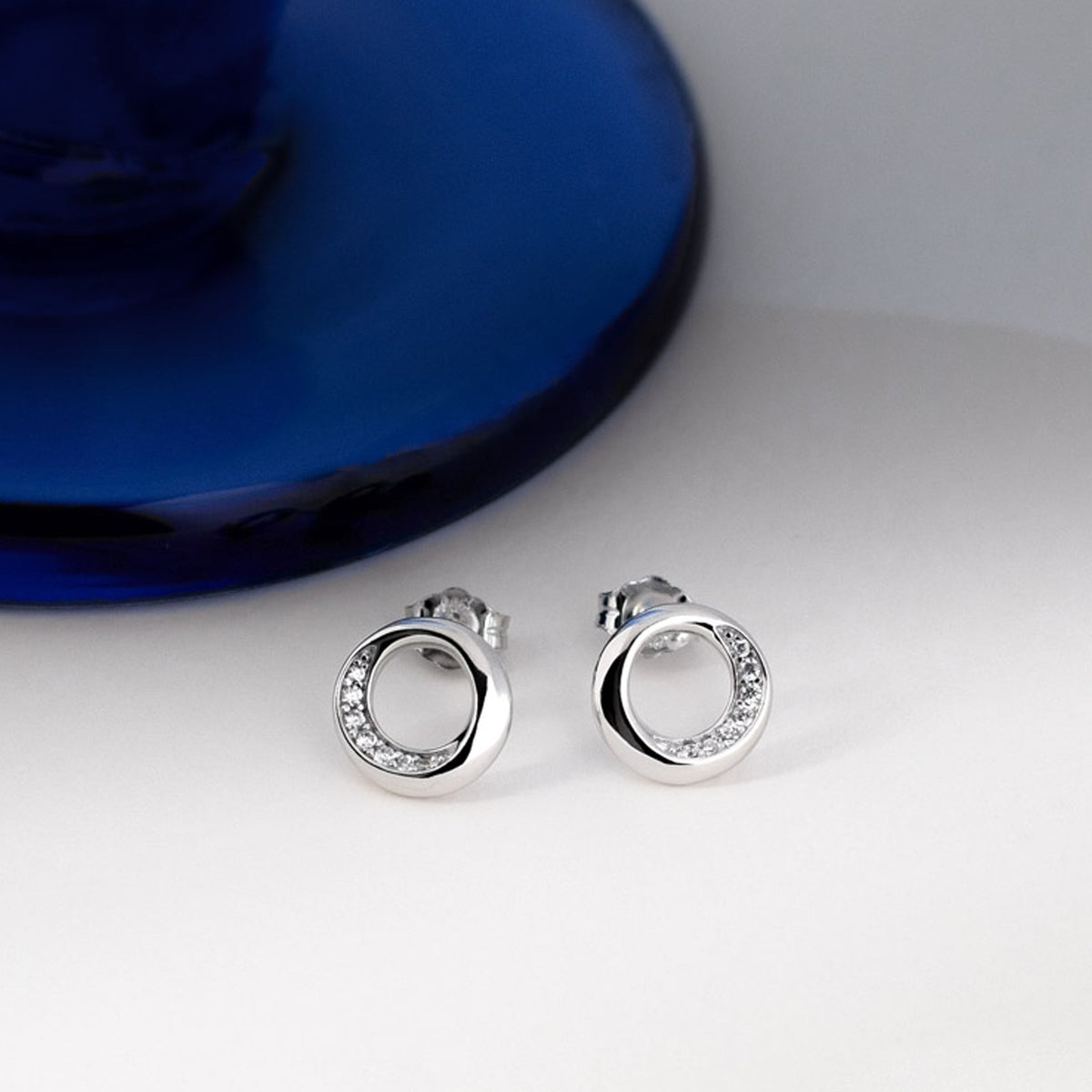 Close-up of Kit Heath Bevel Cirque stud earrings. Sterling silver with pave cubic zirconia stones for subtle sparkle.
