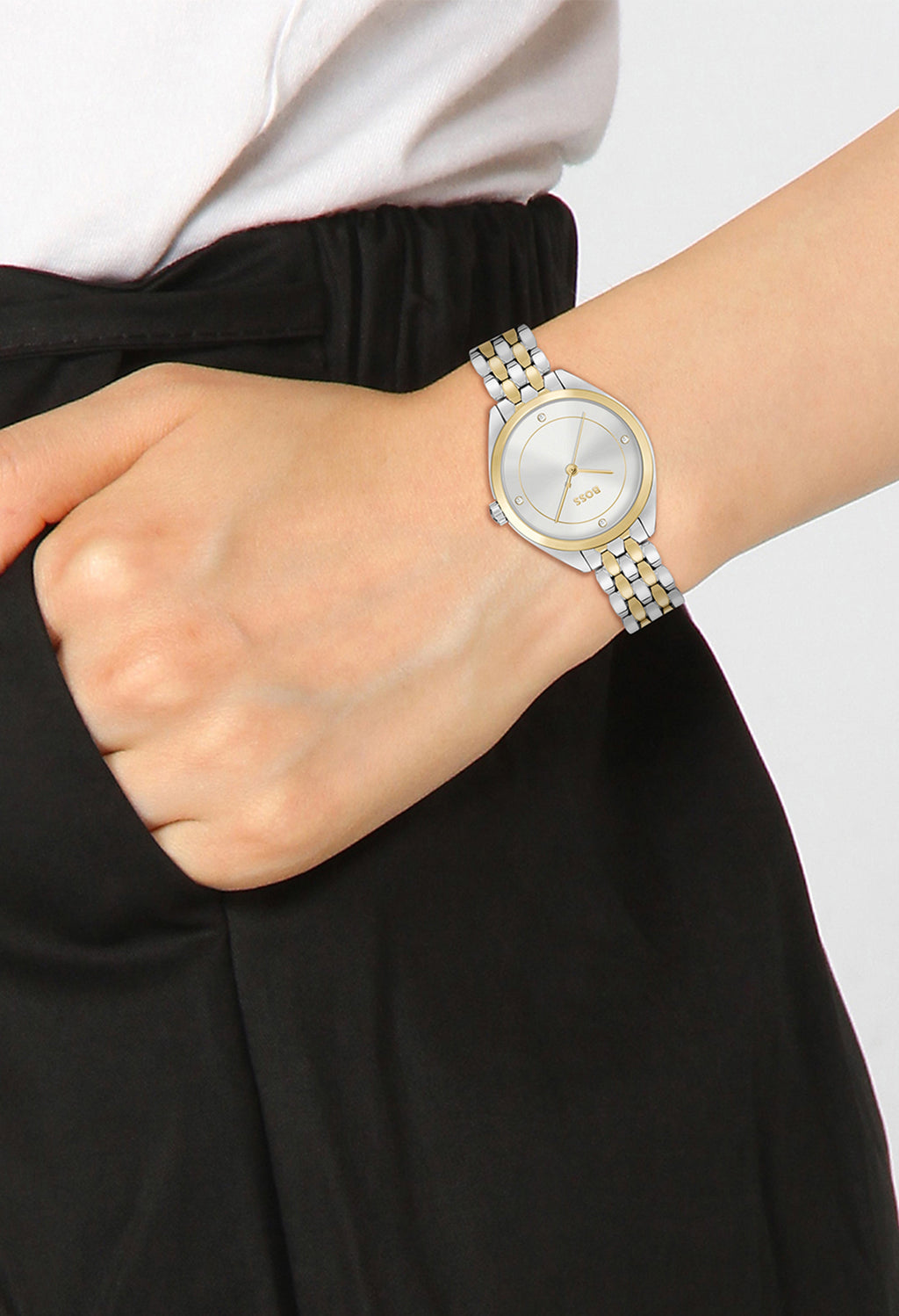 Wrist with a Boss ladies' watch; silver dial with gold accents, stainless steel and gold-plated bracelet.