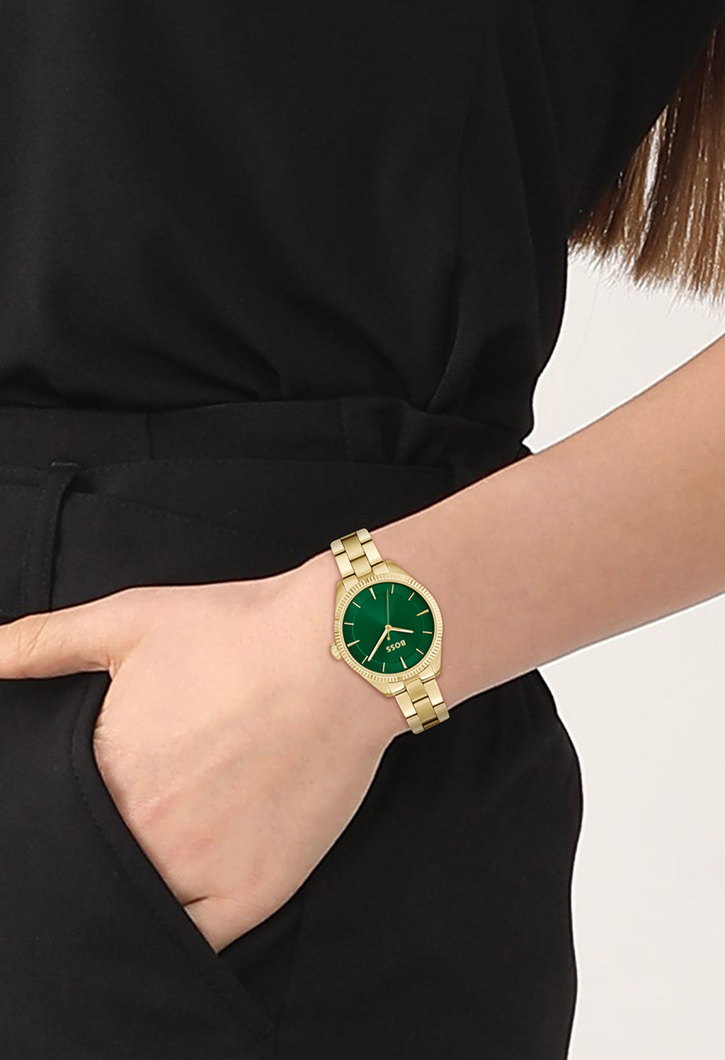 Woman wearing BOSS ladies watch, featuring a sage green dial and gold-plated bracelet, showcasing design and fit.