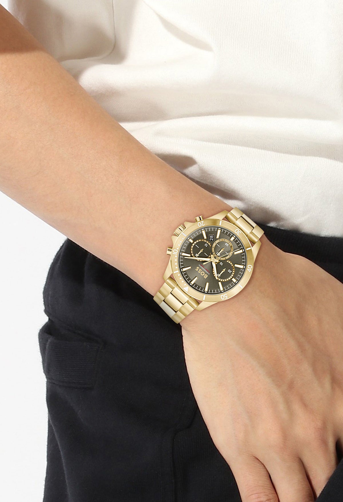 Close-up of the Boss Troper watch in gold, showing the olive green dial and gold plated bracelet on a wrist.