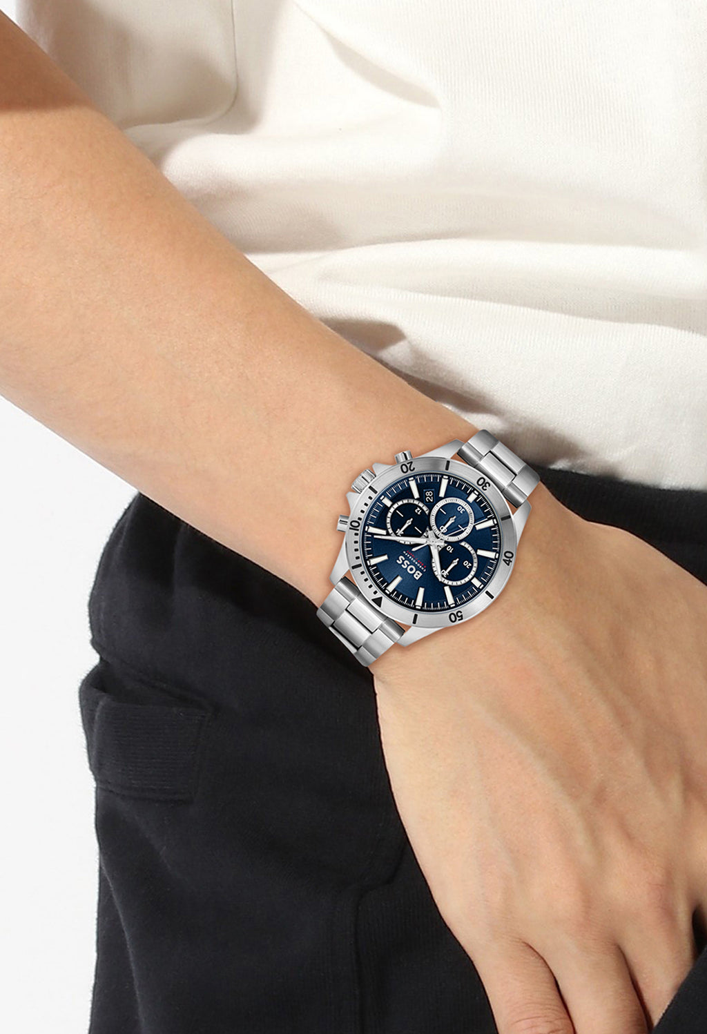 Close-up of BOSS Troper chronograph watch on wrist, showcasing stainless steel bracelet and blue dial detail.