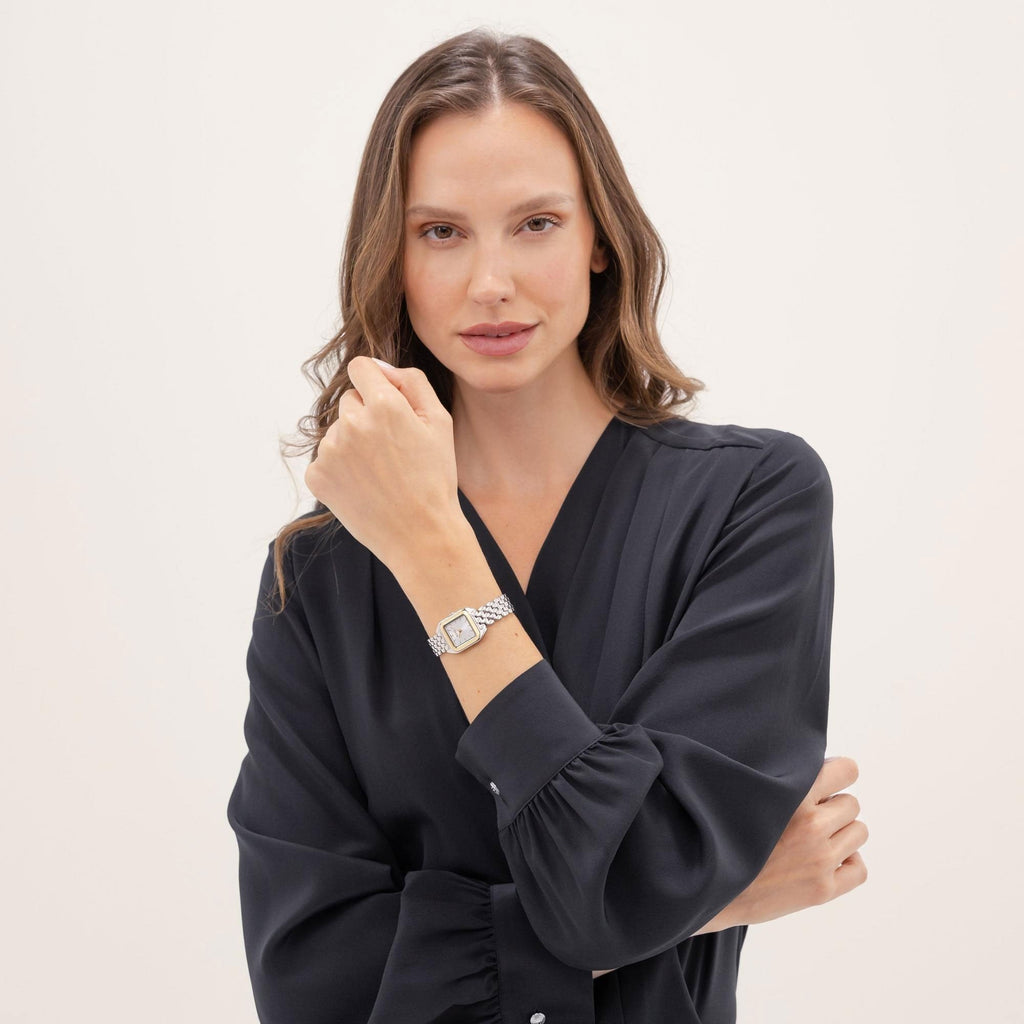 Woman in black dress with watch on wrist.
