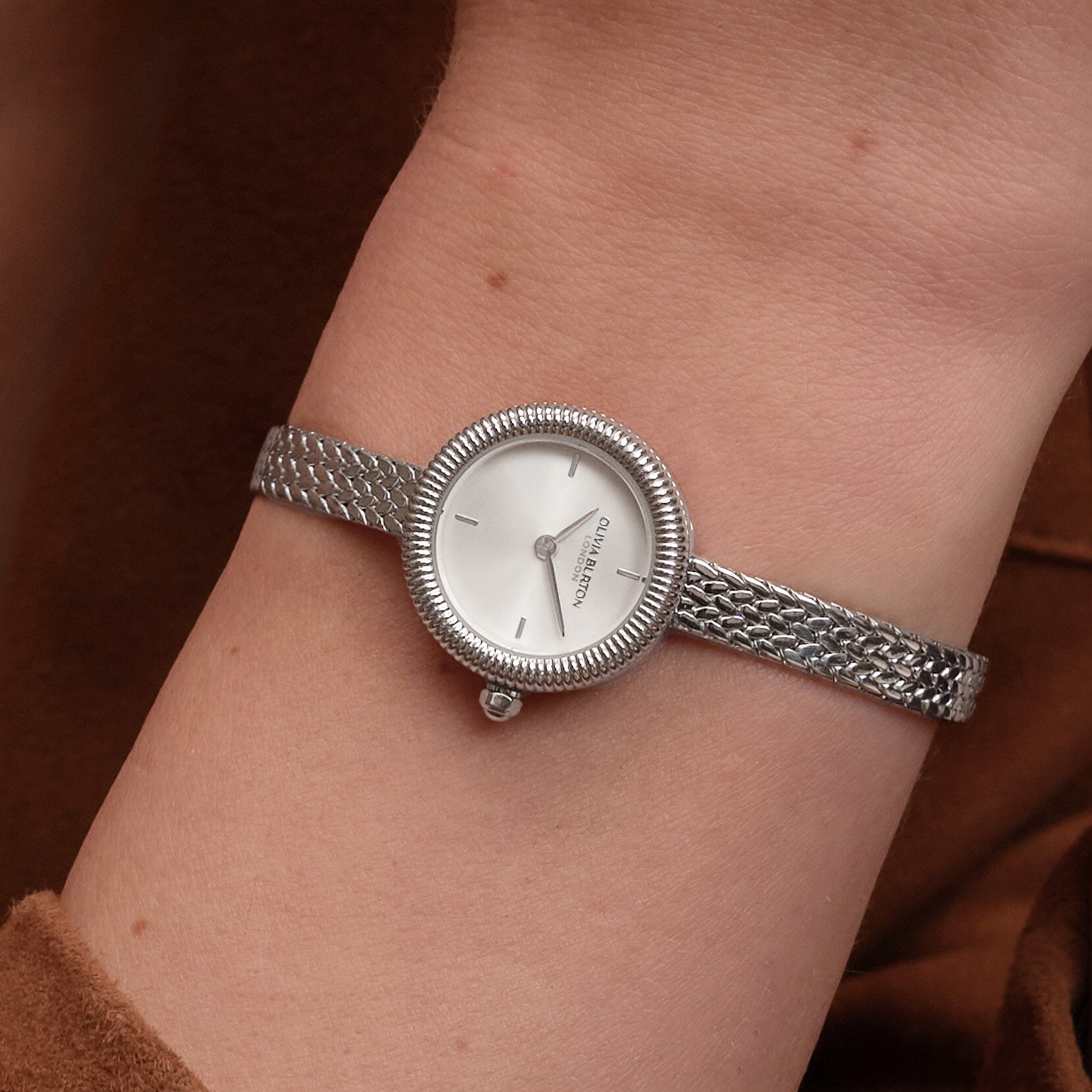 Wrist with silver watch.
