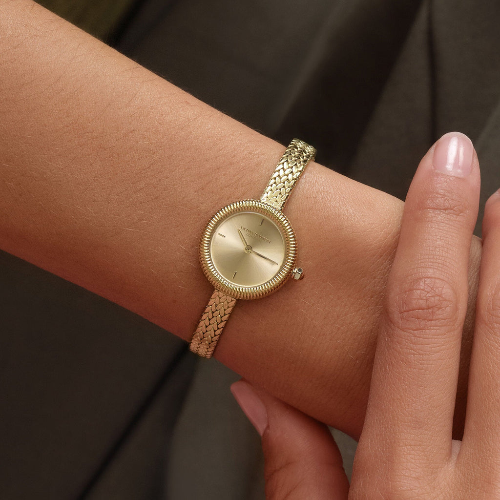 Gold watch on a woman's wrist.